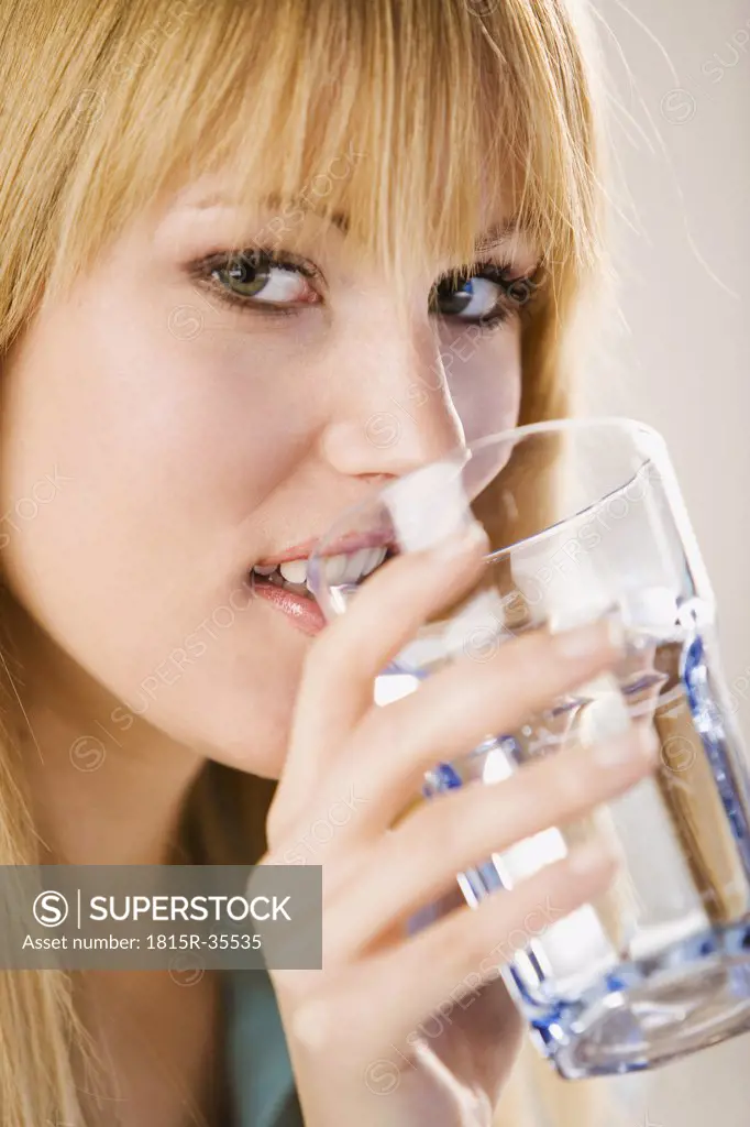 Young woman holding water glass, portrait