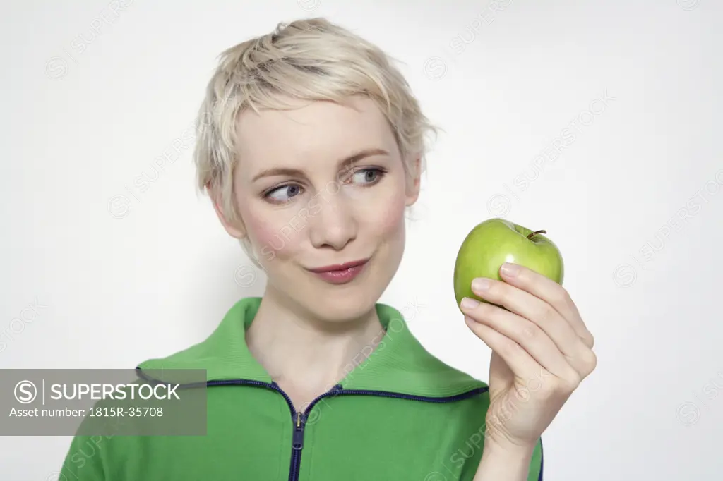 Young woman holding apple, portrait