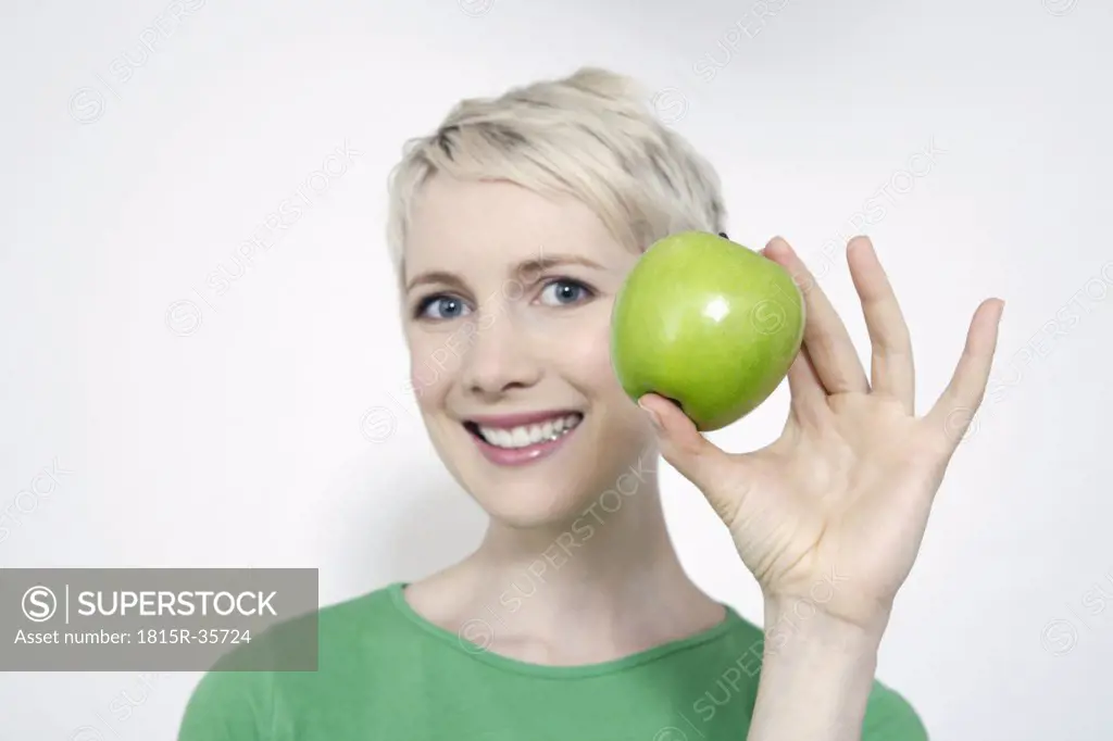 Young woman holding a green apple, portrait