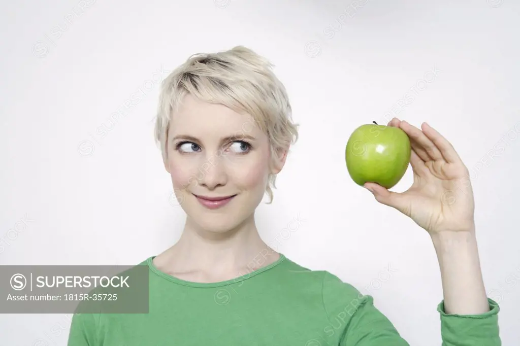 Young woman holding a green apple, portrait