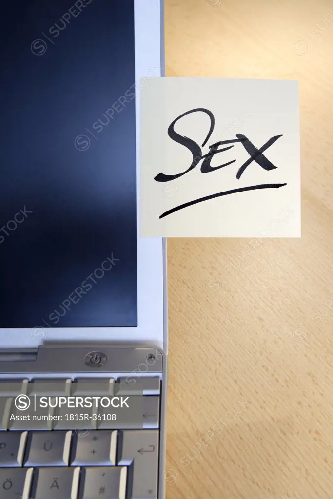 Adhesive note on laptop saying ""Sex""