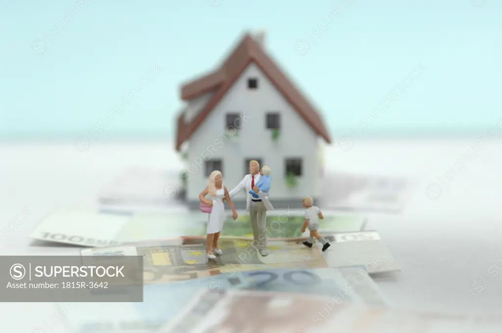 Pastic figurines on banknotes, house in background