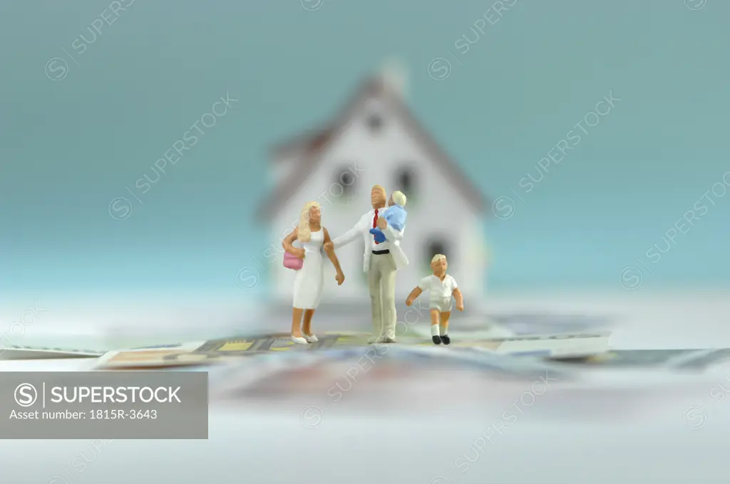Pastic figurines on banknotes, house in background