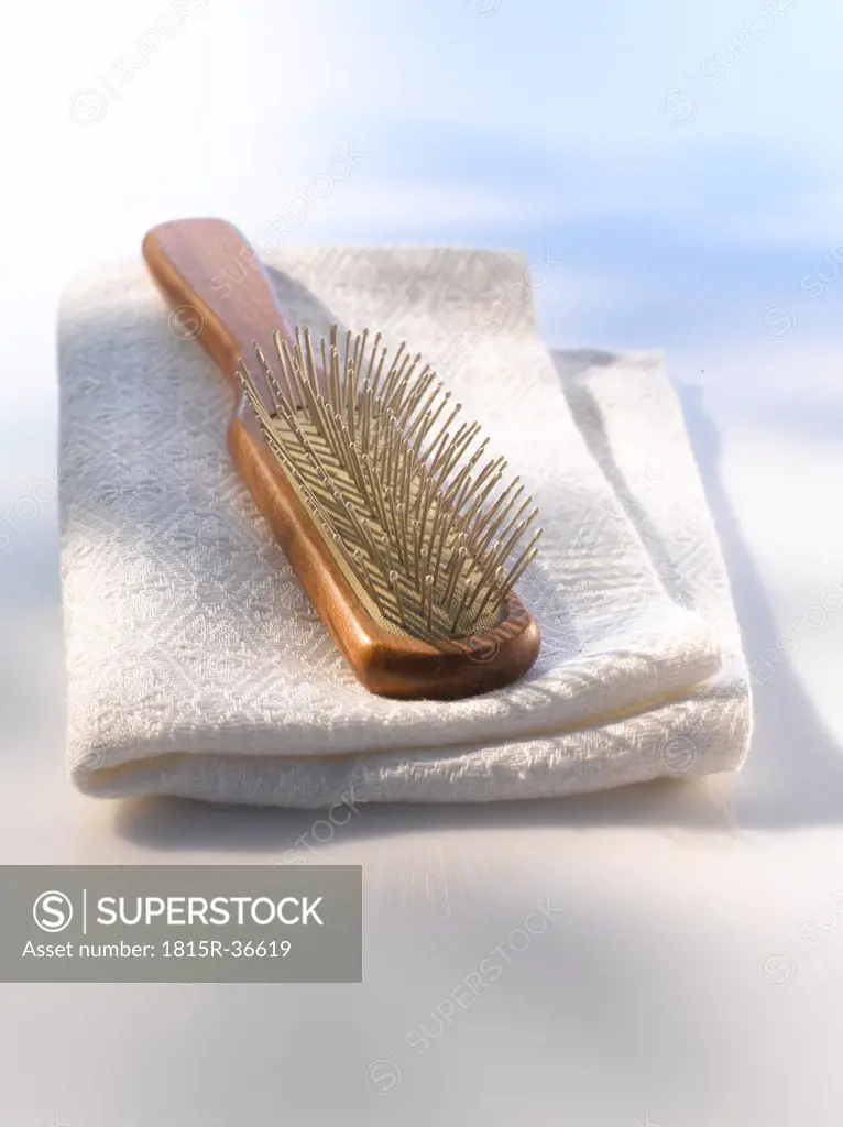 Hairbrush on white towel, close up