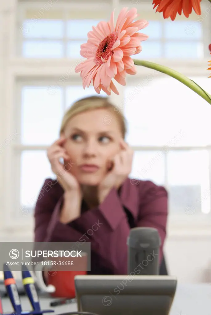 Woman sitting in office, thinking