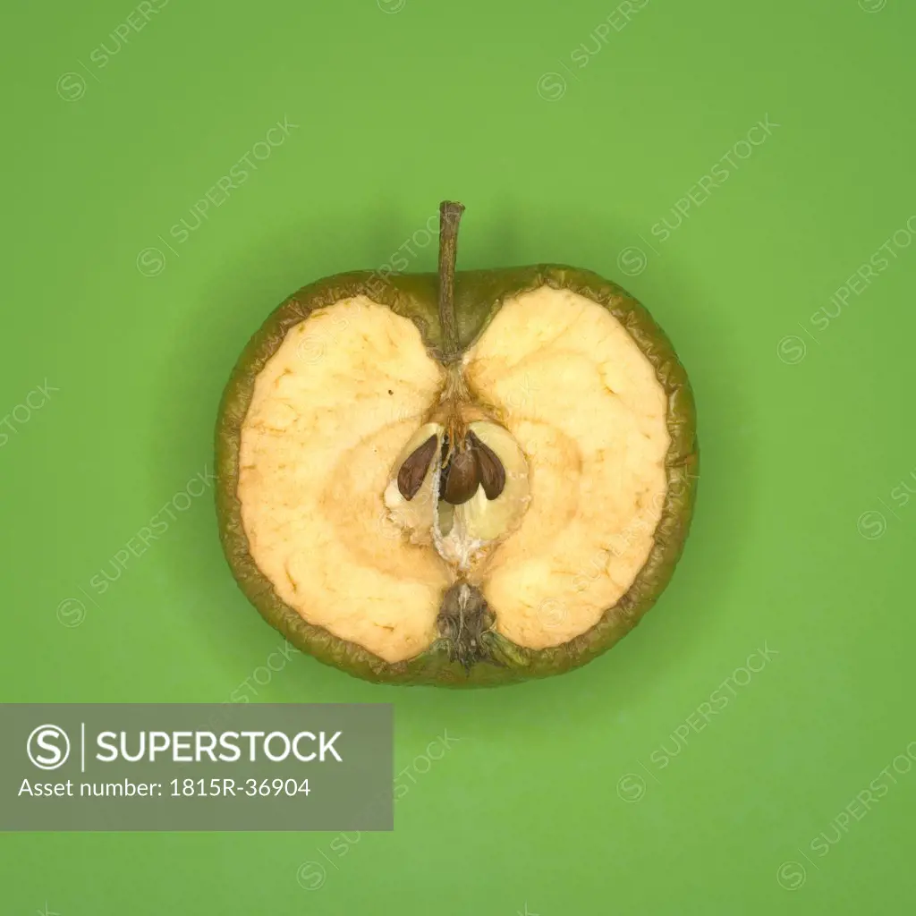 Rotting green apple cut in half, elevated view