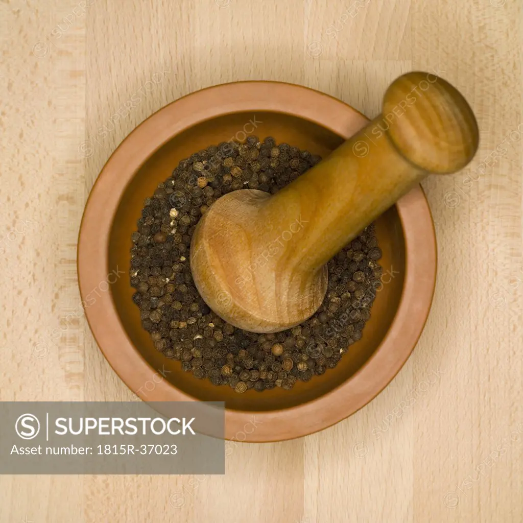 Peppercorns in mortar with pestle, elevated view