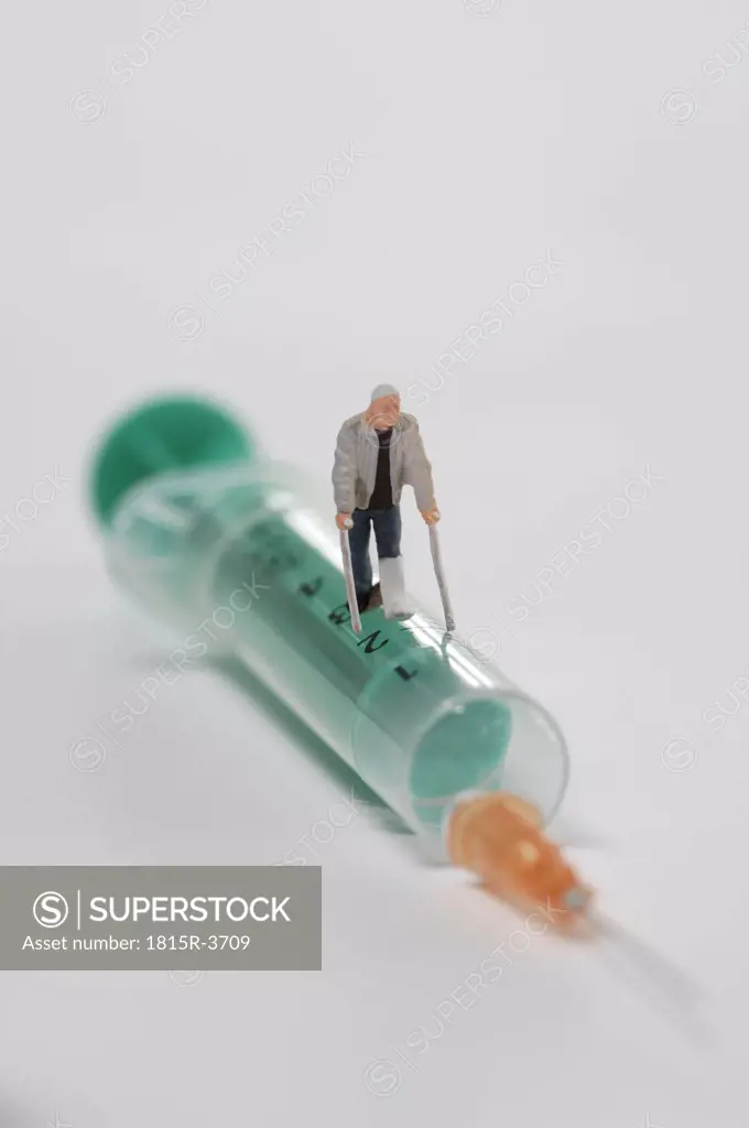 Plastic figurine walking on Syringe