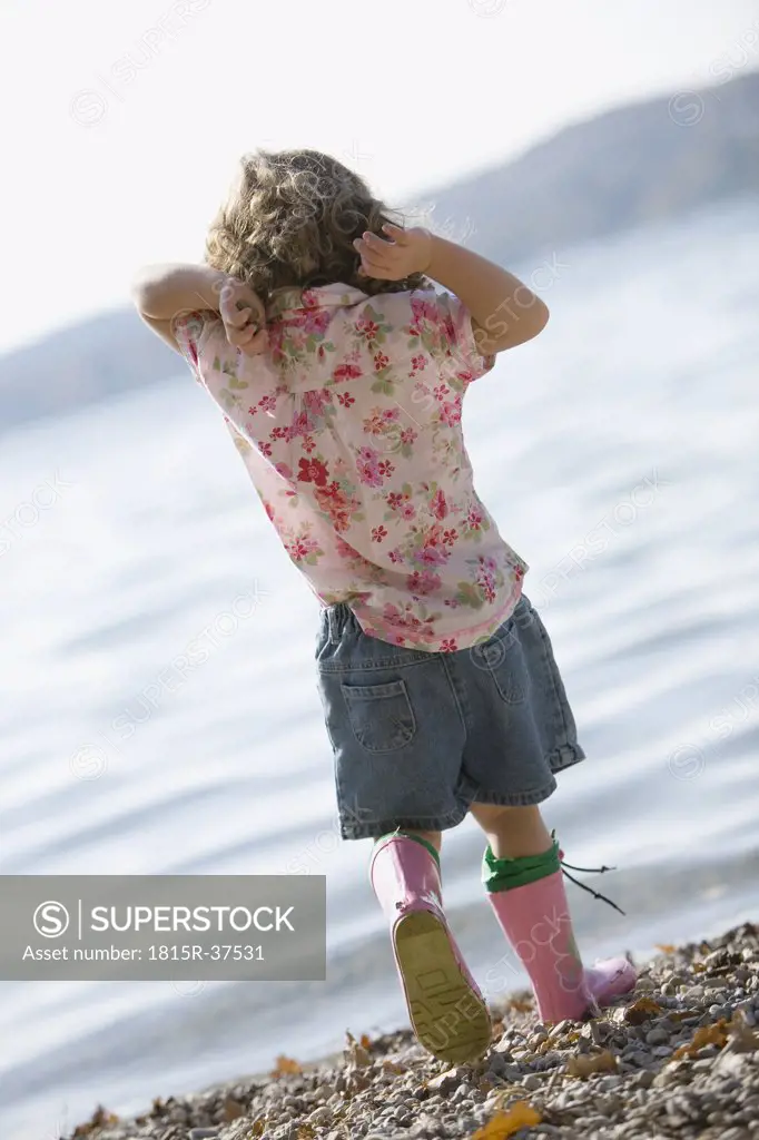 Germany, Bavaria, Ammersee, little girl (3-4) playing on beach
