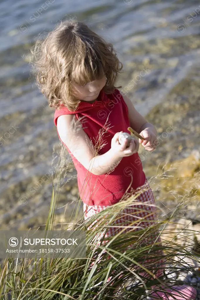 Germany, Bavaria, Ammersee, little girl (3-4) playing on beach