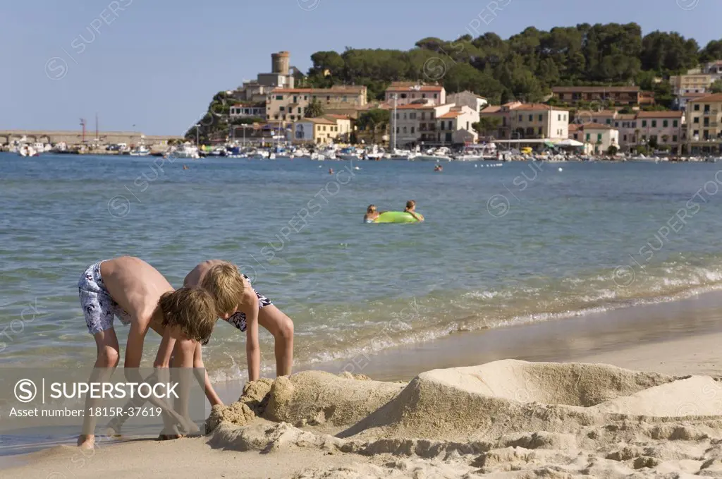 Italy, Elba, Marina di Campo, children (10-12) playing on the beach
