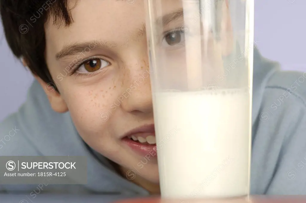 Boy (8-9) with glass of milk, close-up, portrait