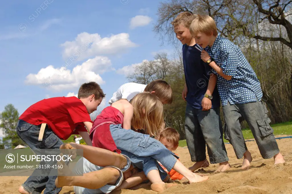 Children (6-9) play fighting on playground