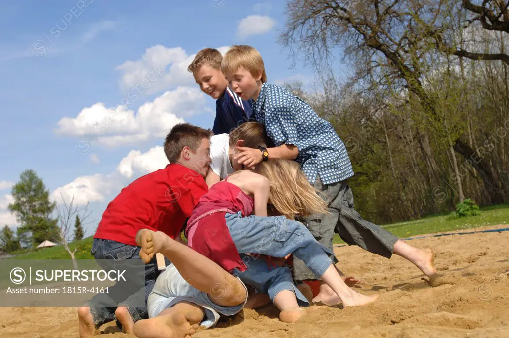 Children (6-9) play fighting on playground
