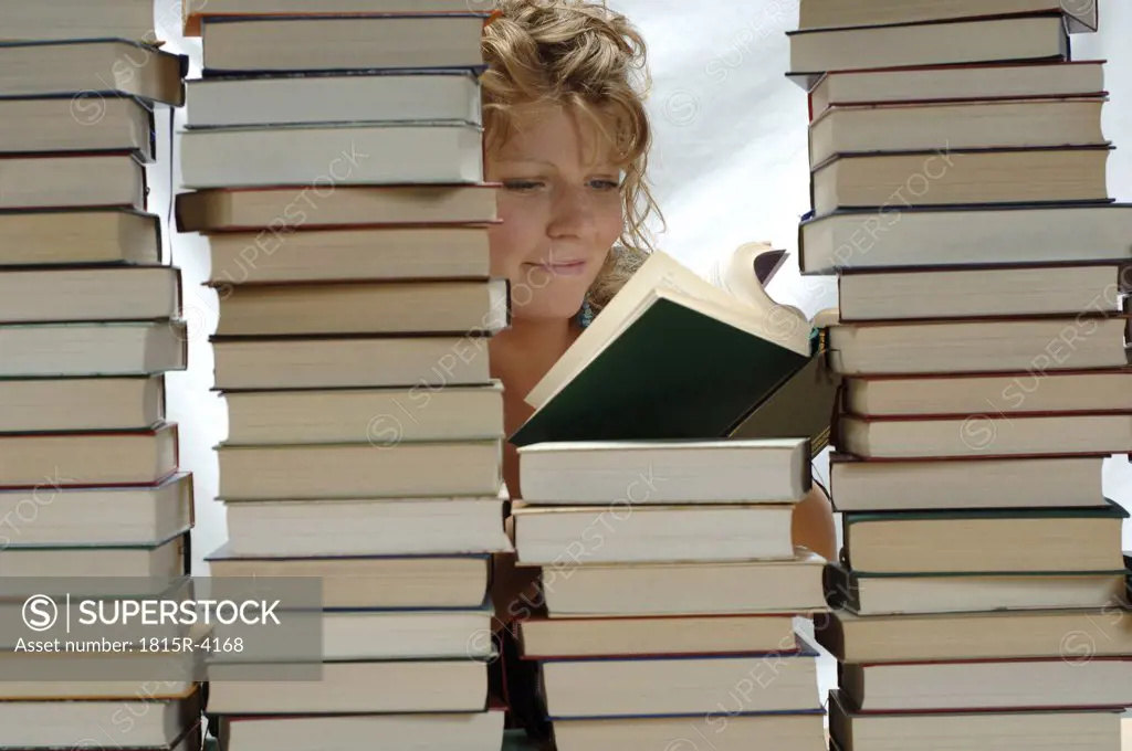 Woman with pile of books, smiling