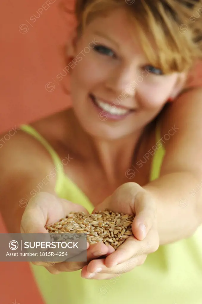 Young woman holding grains, close-up