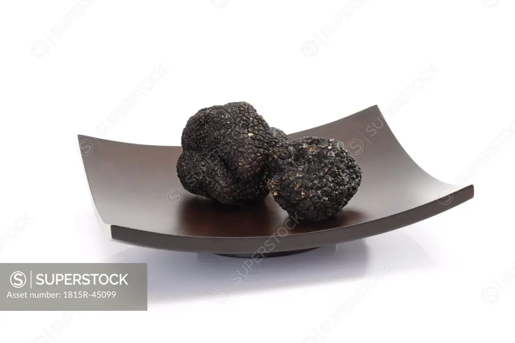 Black truffles on wooden bowl, close-up