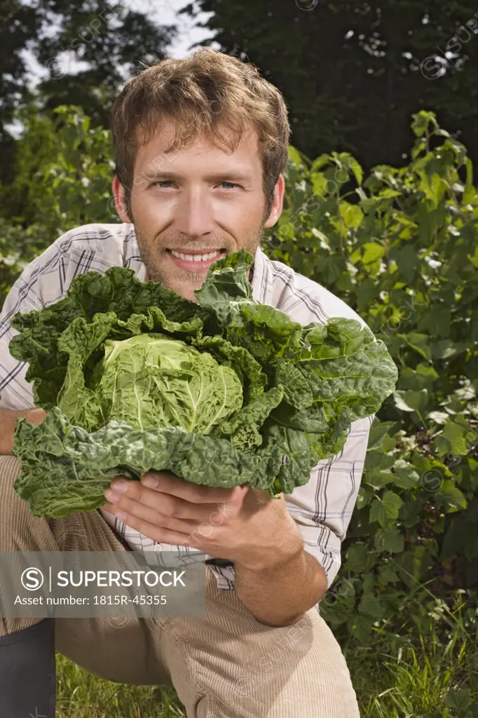 Man holding cabbage, portrait