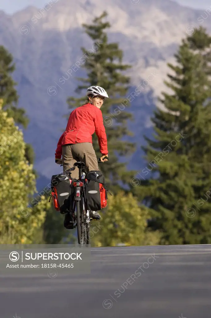Austria, Tyrol, Ahornboden, Mountainbiker riding across highway
