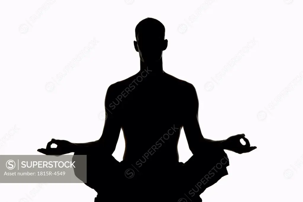 Man exercising yoga, silhouette