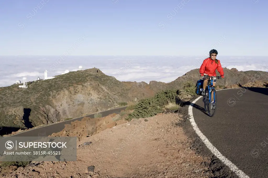 Spain, The Canary Islands, La Palma, Woman mountain biking on highway