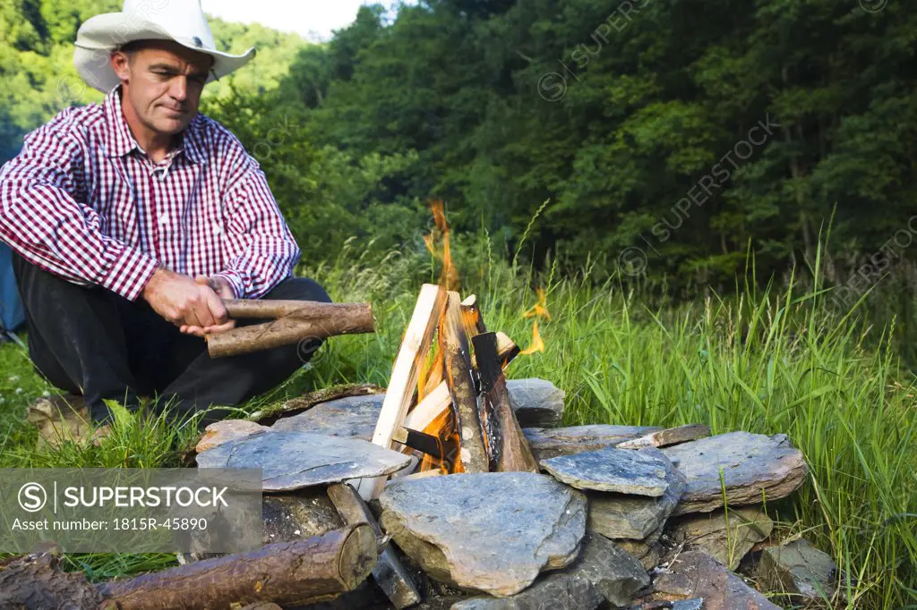 Man with stetson lighting campfire