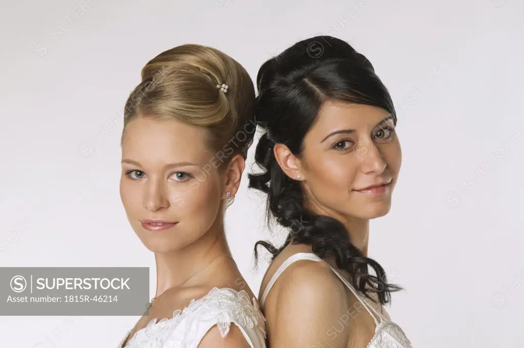 Young brides standing back to back, portrait
