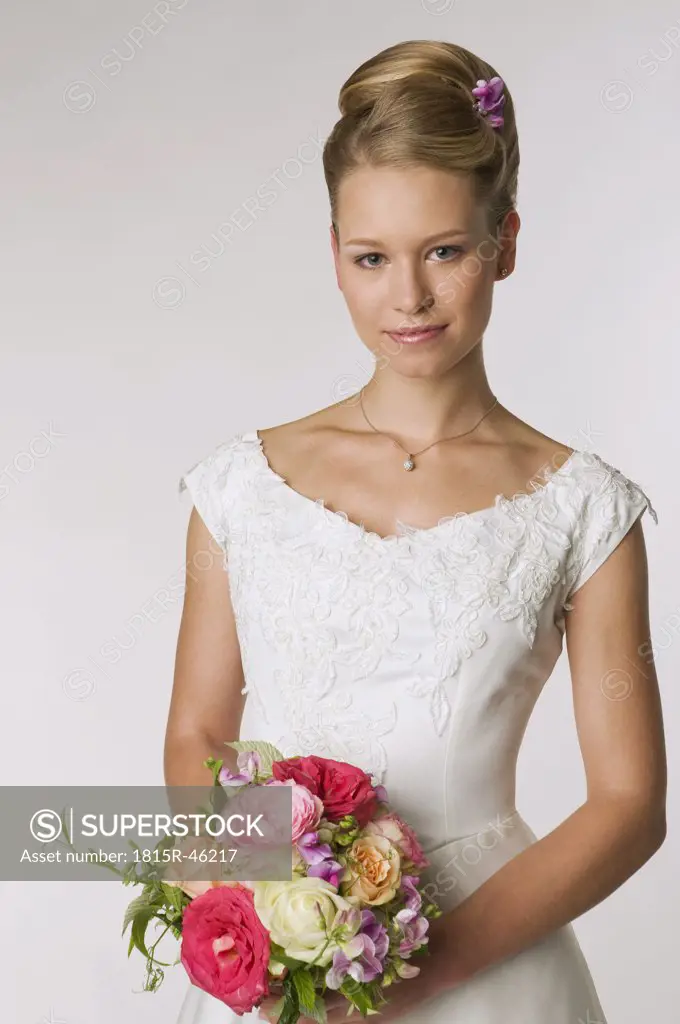 Young bride holding bridal bouquet, portrait