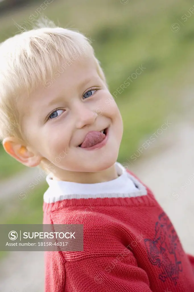 Little boy (3-4) poking his tongue out, portrait