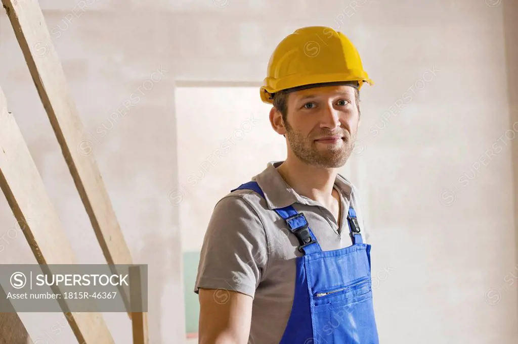 Construction worker at construction site, smiling, portrait