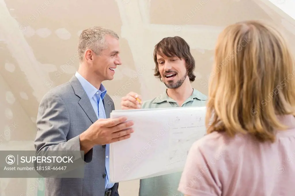 Architect discussing construction plan with young couple
