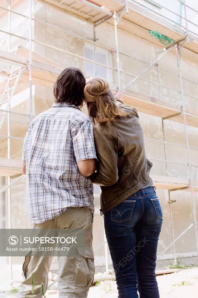 Couple Looking at New Home Construction, rear view