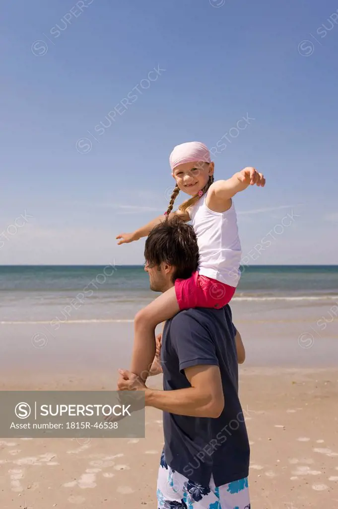 Germany, Baltic sea, Father carrying daughter 6 on shoulders