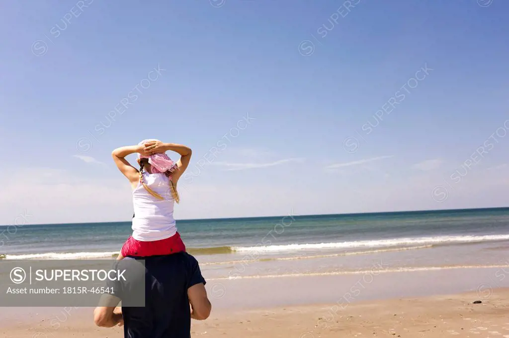 Germany, Baltic sea, Father carrying daughter 6 on shoulders, rear view