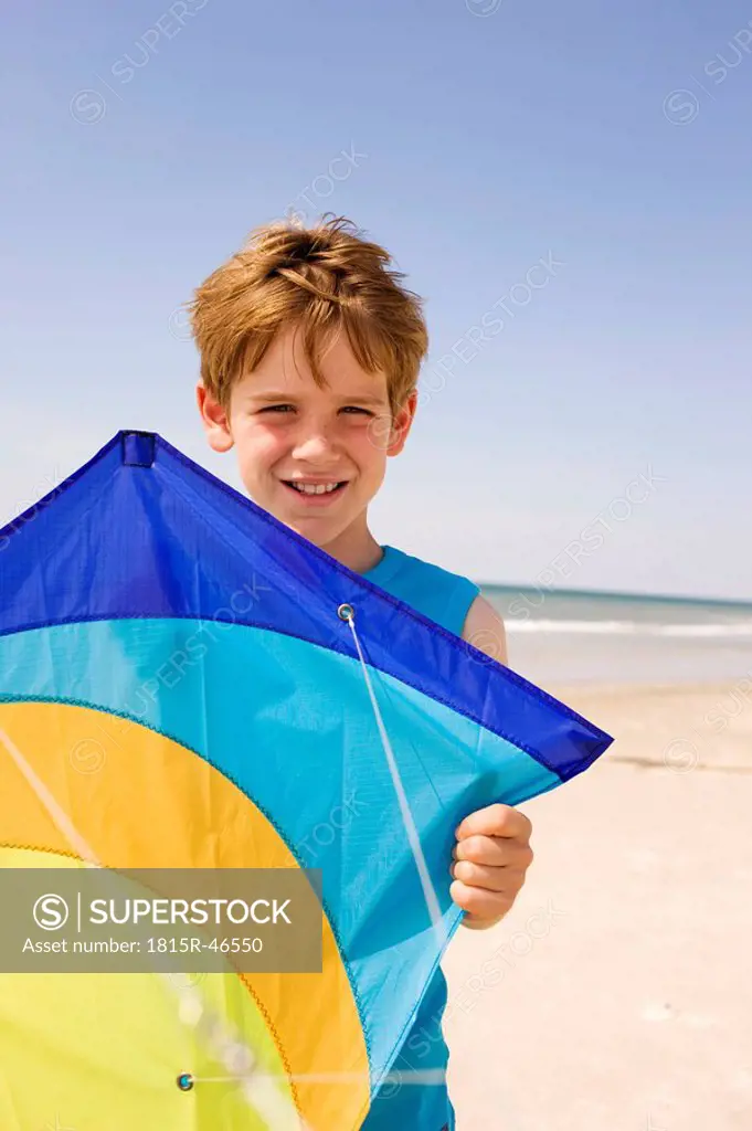 Germany, Baltic sea, Boy 8_9 holding kite, portrait, close_up