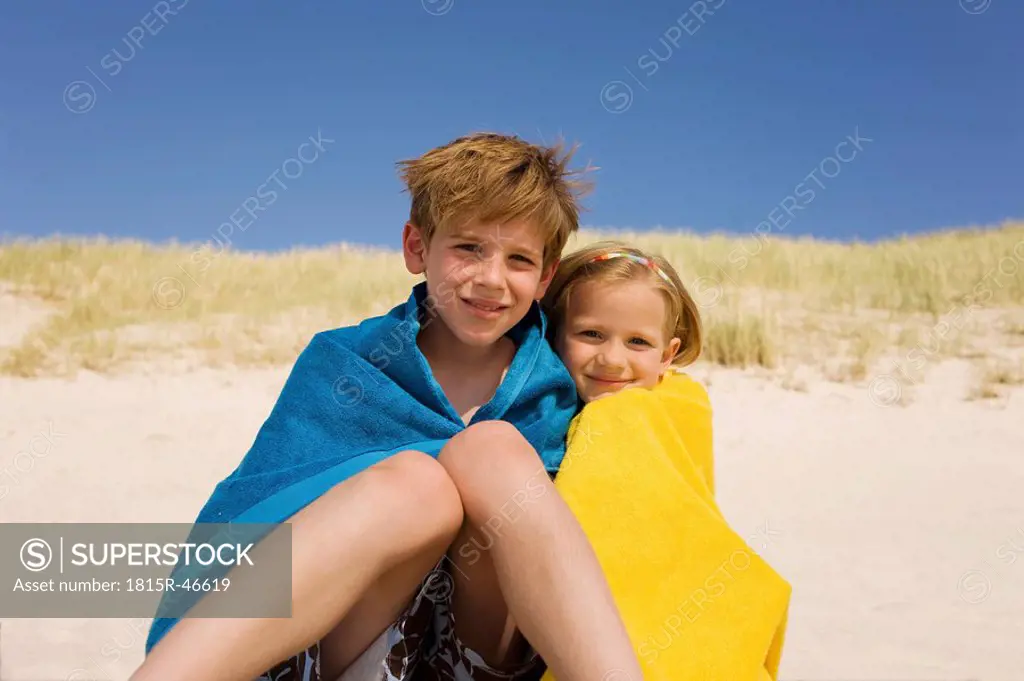 Germany, Baltic sea, Boy 8_9 and girl 6_7 wrapped in towels, portrait