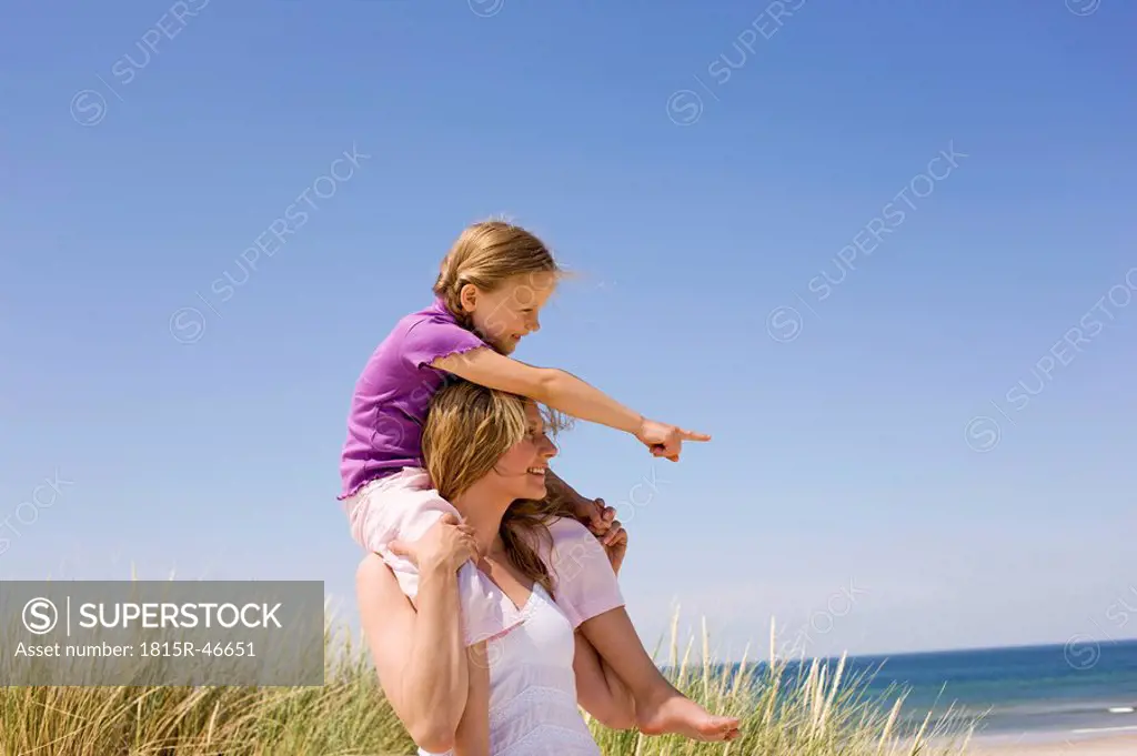 Germany, Baltic sea, Mother carrying daughter 6_7 on shoulders, portrait