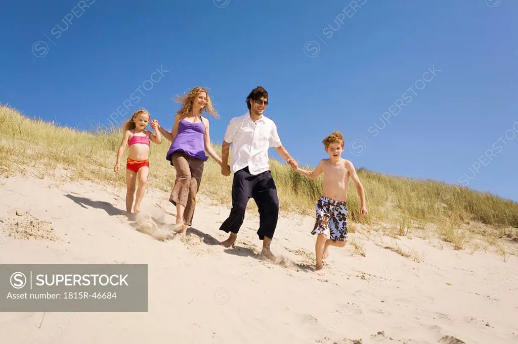 Germany, Baltic sea, Family running down sand dunes