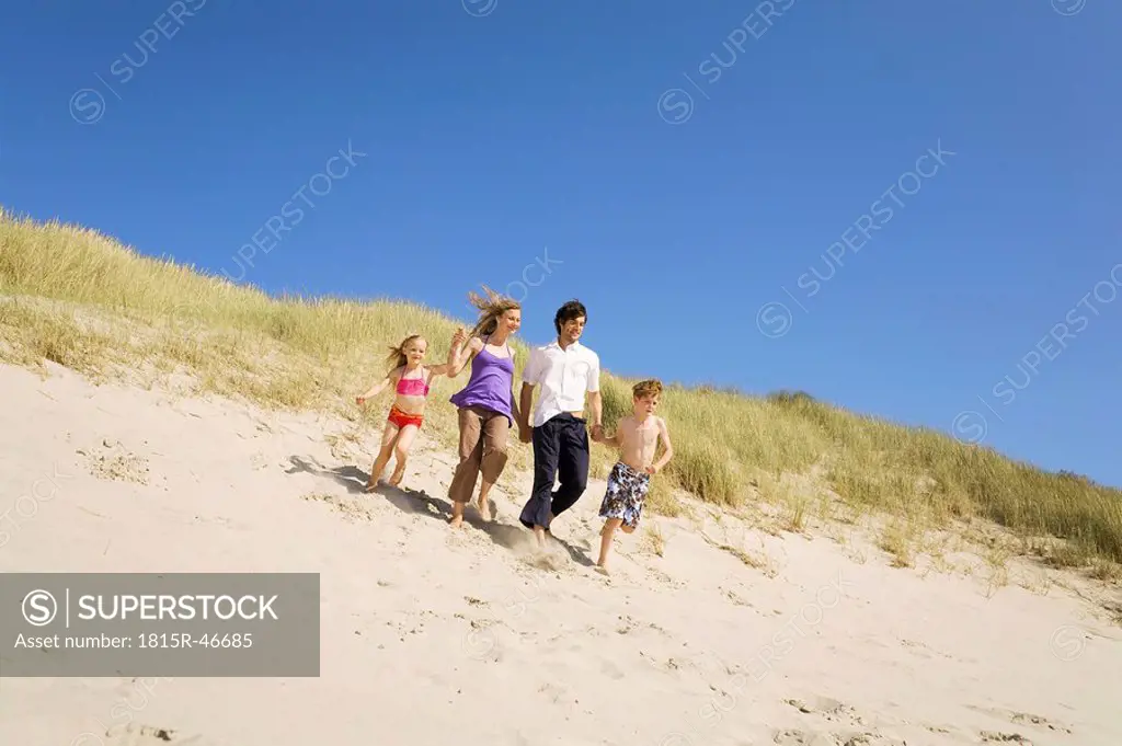 Germany, Baltic sea, Family running down sand dunes