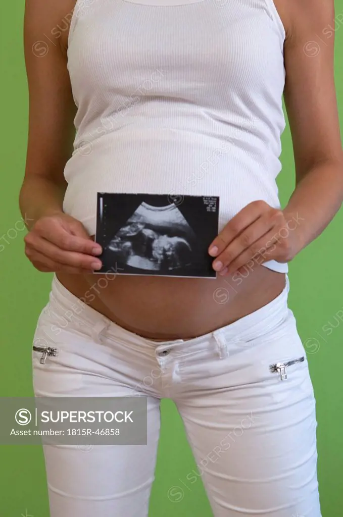 Pregnant woman holding ultrasonic picture, mid_section, close_up