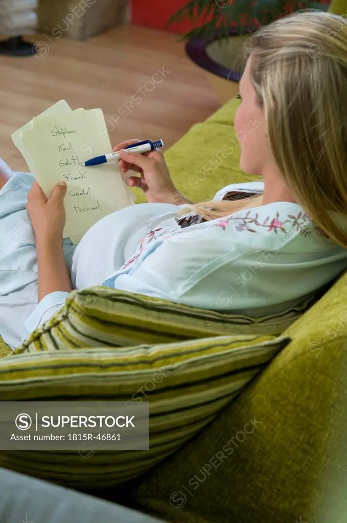 Pregnant woman writing down babys names
