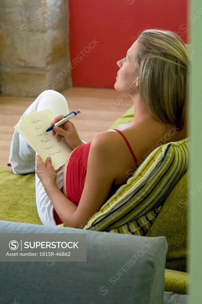 Pregnant woman writing down babys names