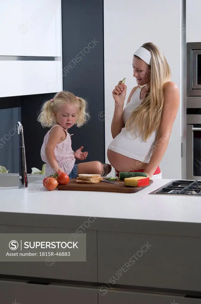 Pregnant mother and daughter 3_4 in the kitchen