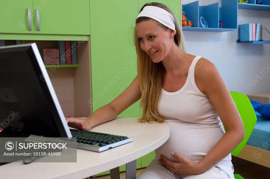 Pregnant woman sitting in front of a computer