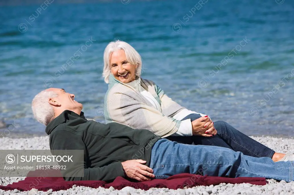 Germany, Bavaria, Walchensee, Senior couple relaxing on lakeshore