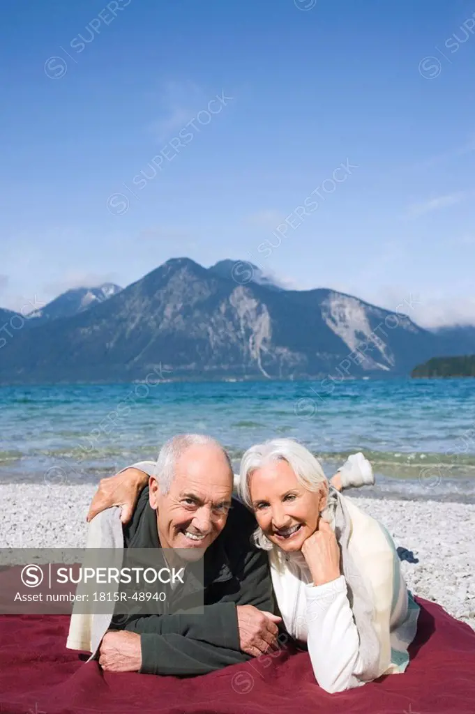 Germany, Bavaria, Walchensee, Senior couple relaxing on lakeshore
