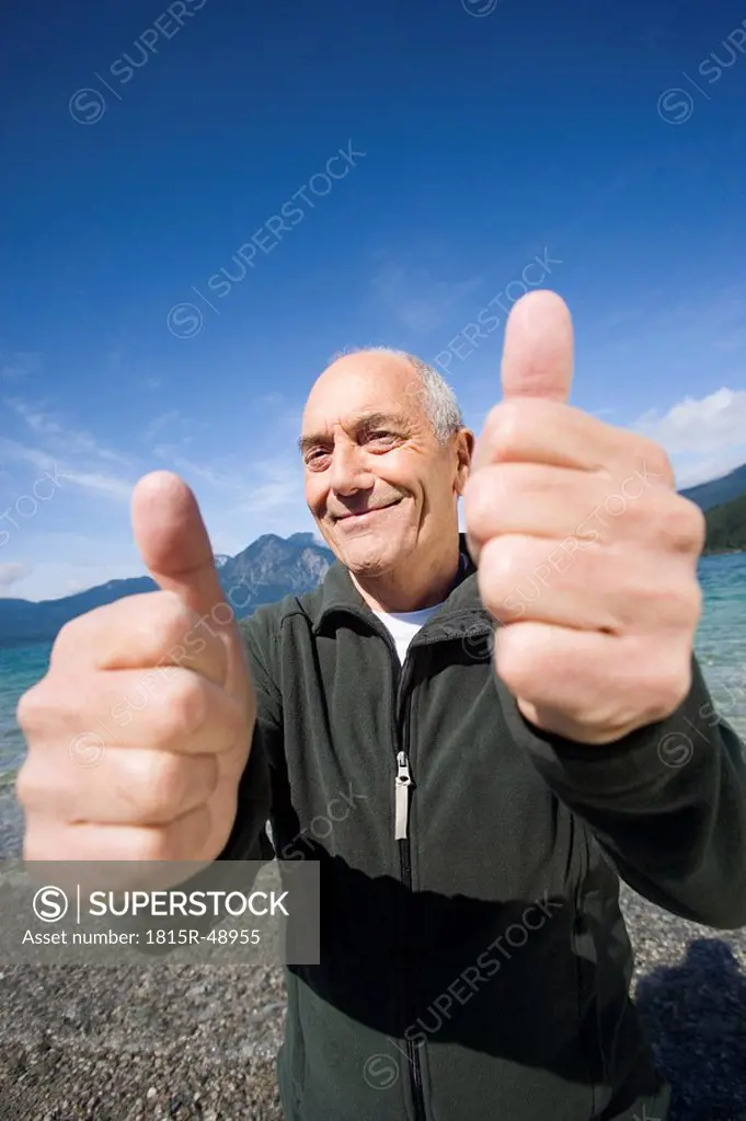 Germany, Bavaria, Walchensee, Senior man rejoicing, thumbs up