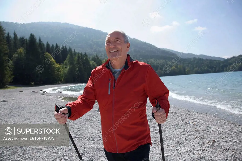 Germany, Bavaria, Walchensee, Senior man with Nordic Walking poles, smiling