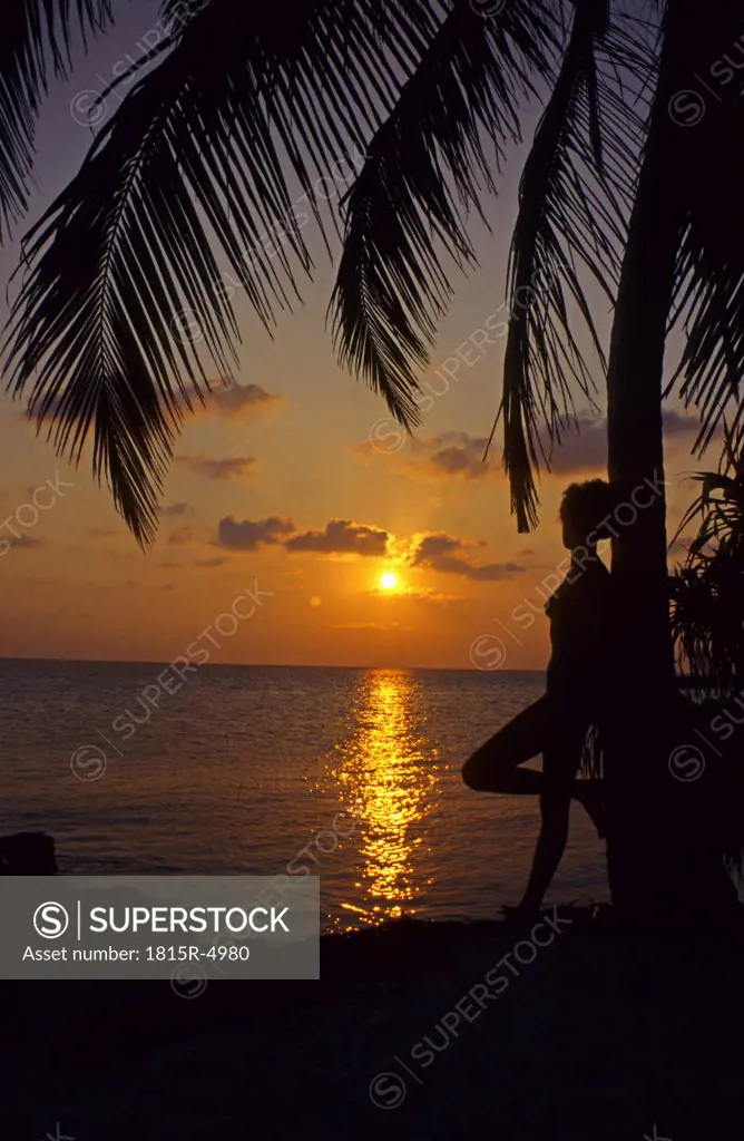 Woman Standing By Palm Tree