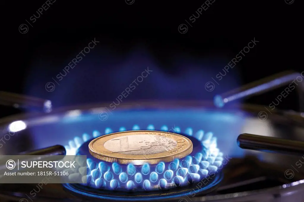 Flame of gas stove and Euro coin, close_up
